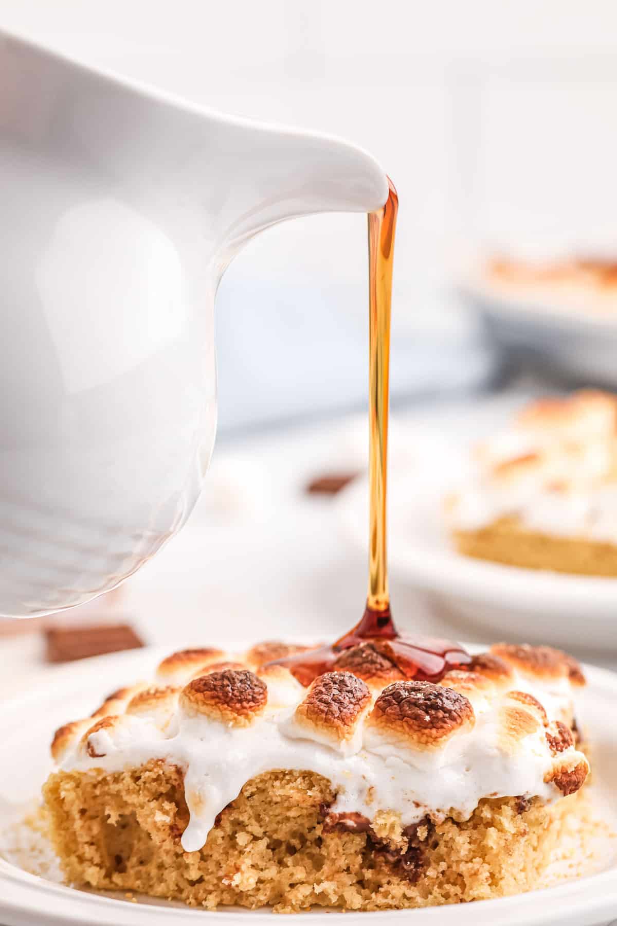 Du sirop versé sur un pancake garni de guimauves.