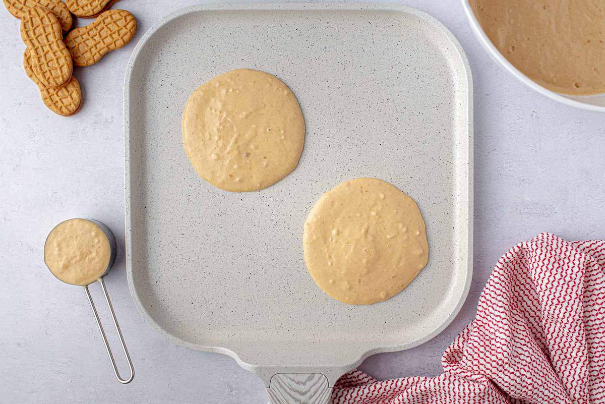 Pancakes non cuits dans une poêle blanche.