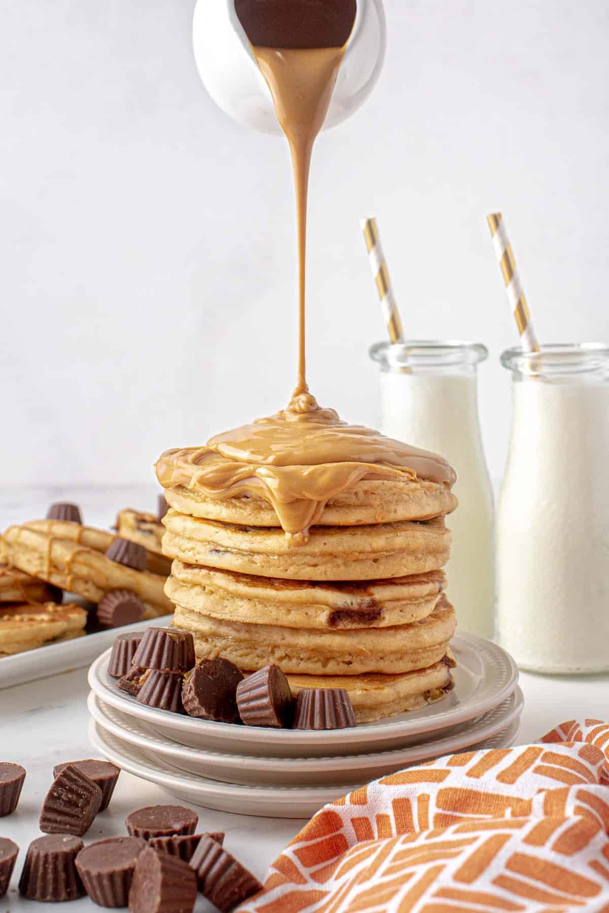 Beurre de cacahuète fondu en train d'être versé sur une pile de pancakes.