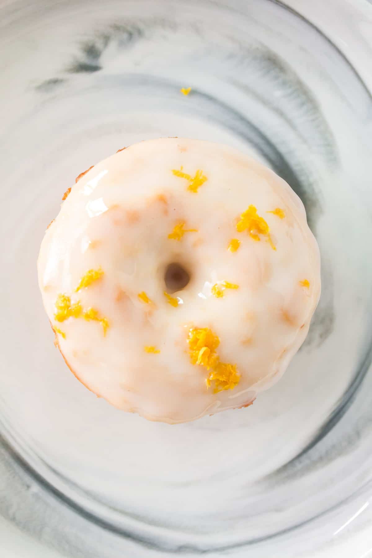 Vue de dessus d'un donut avec glaçage blanc et zest de citron.