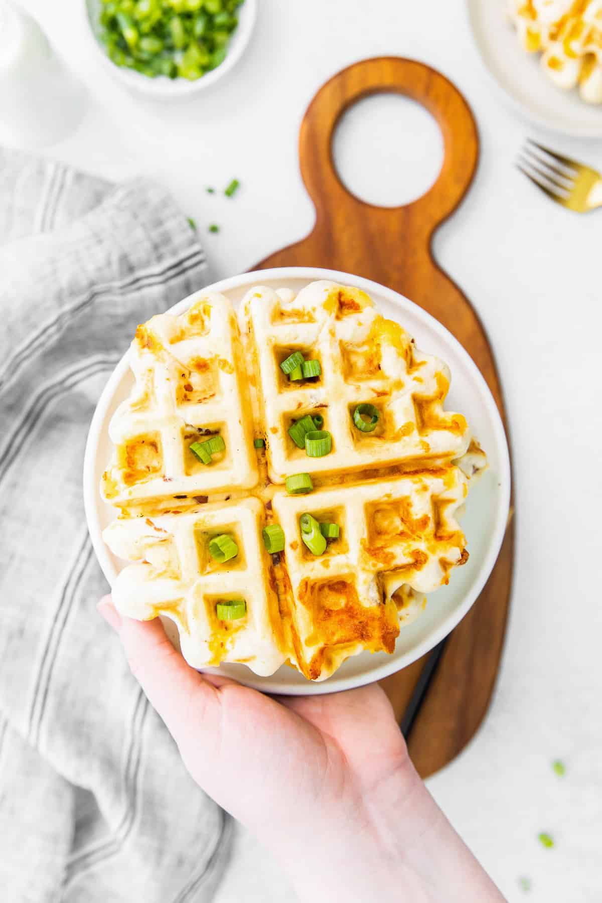 Gaufre garnie de cheddar et d'oignons verts, sur une assiette.