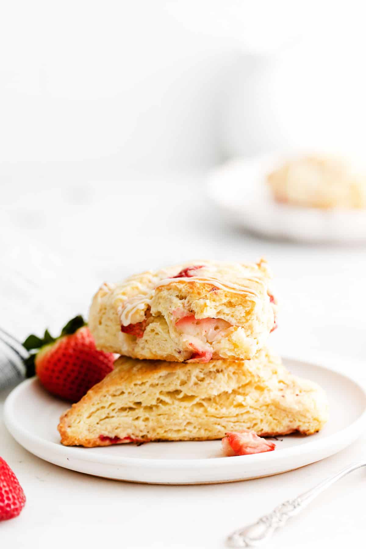 Deux scones aux fraises empilés sur une assiette.