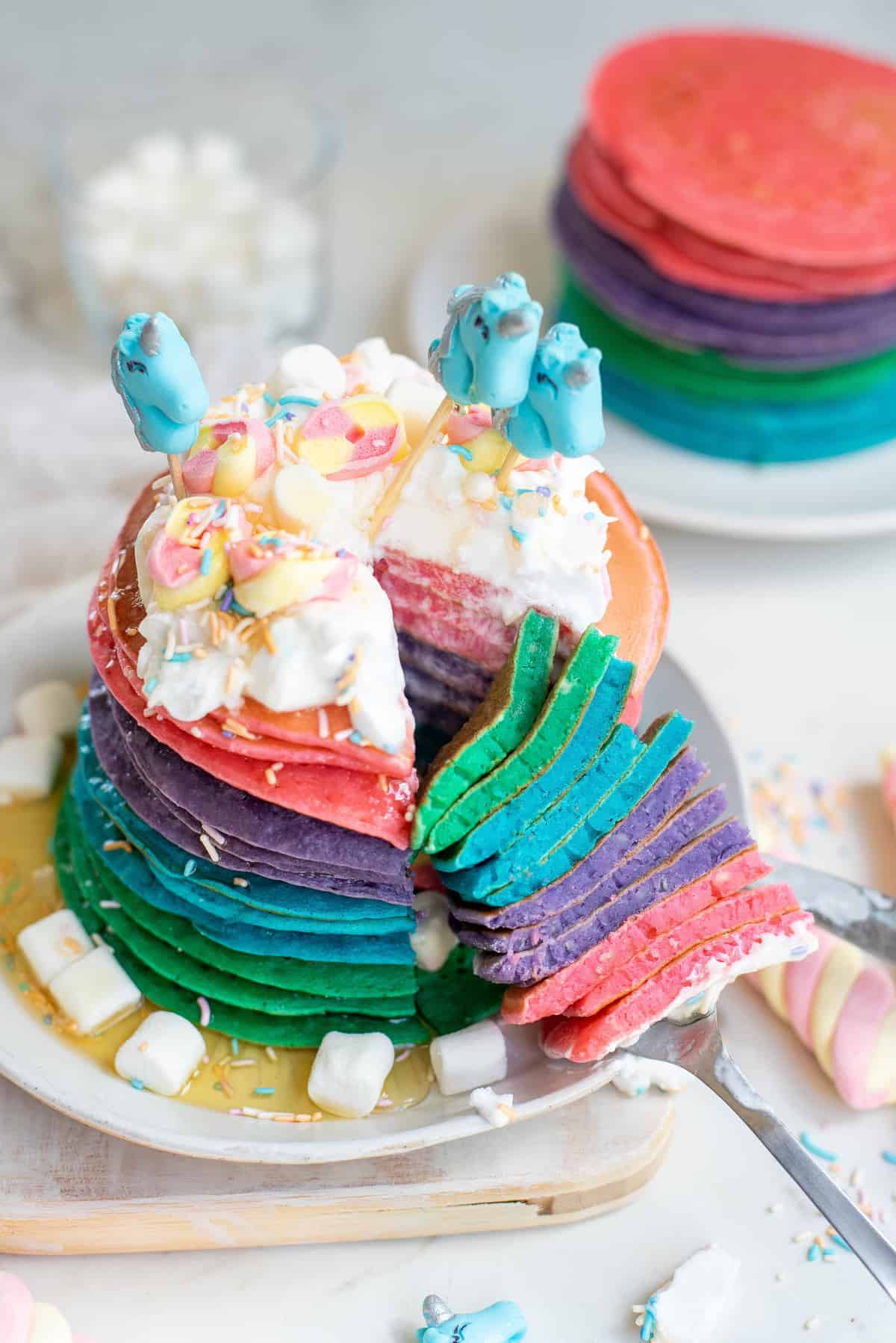 Grande pile de pancakes licorne colorés.
