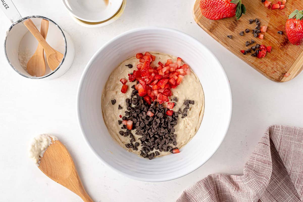 Fraises et pépites de chocolat sur le dessus de la pâte à pancakes.