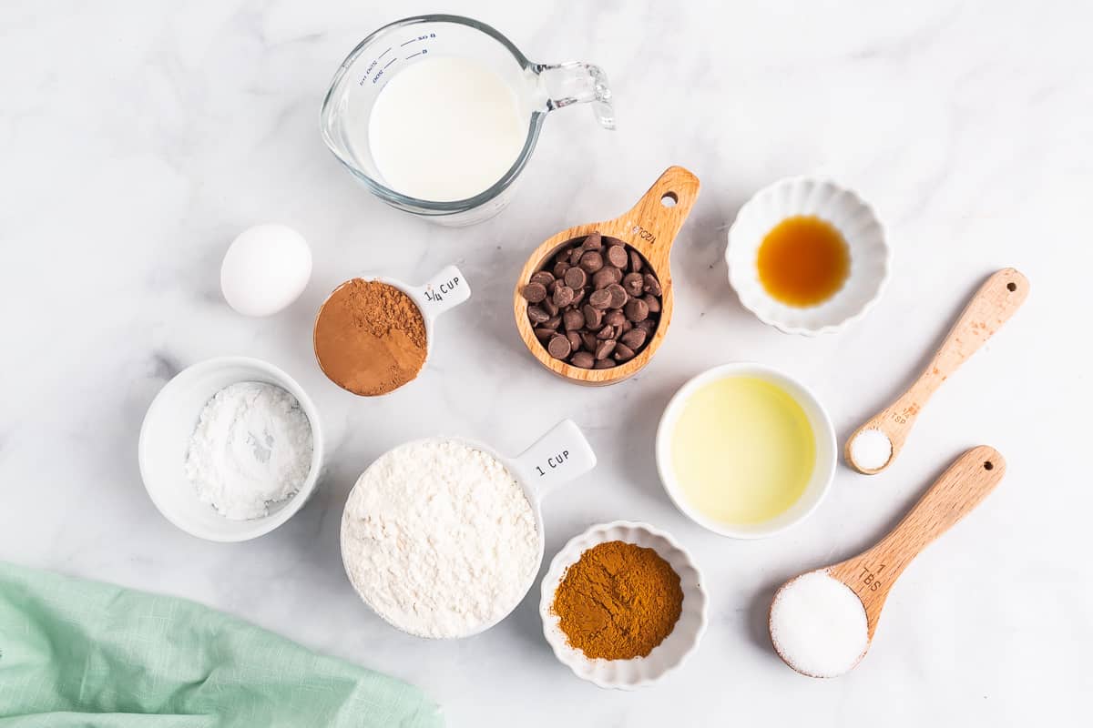 Bol d'ingrédients, y compris de la poudre de cacao, des pépites de chocolat, de la farine, de la poudre d'espresso, de la vanille et du sucre.