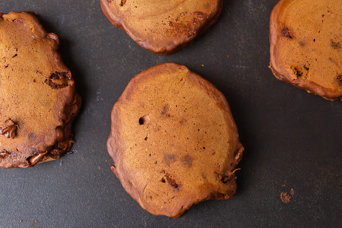 Pancakes au chocolat cuits sur une plaque noire.
