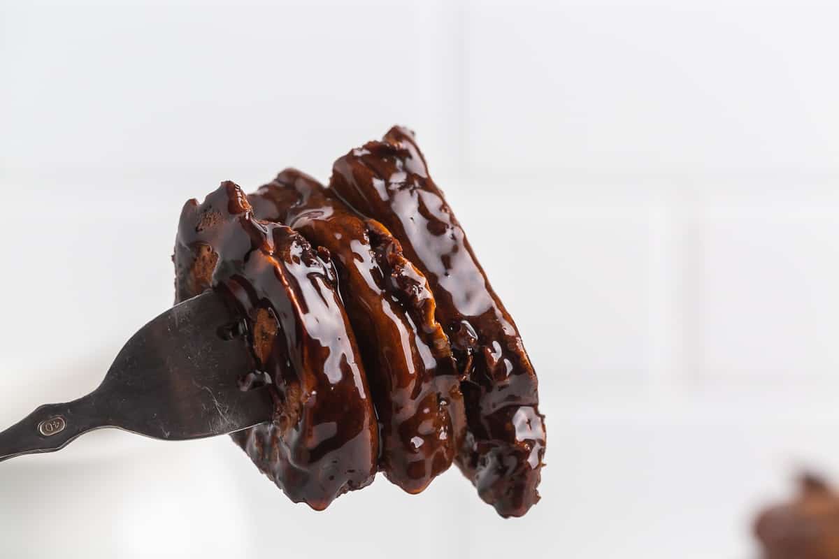 Pancakes au chocolat trempés dans du chocolat sur une fourchette.