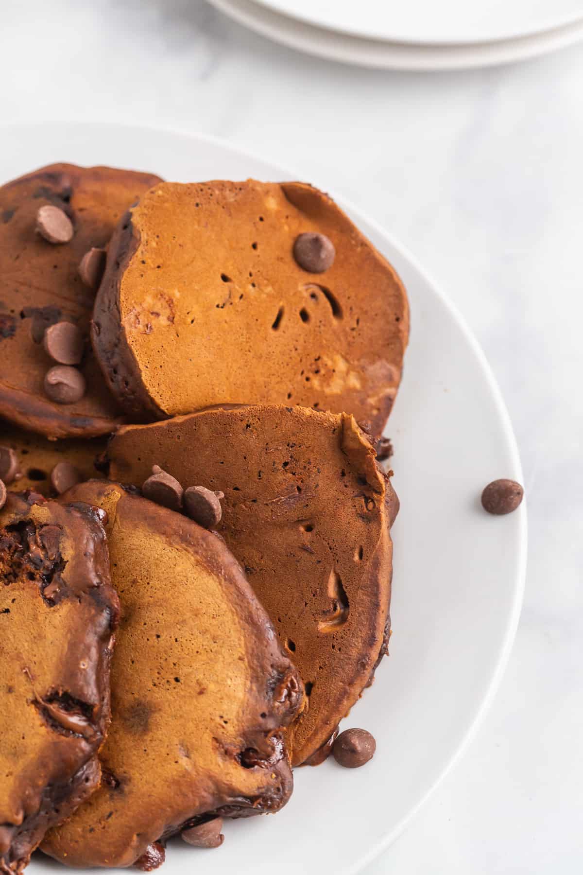 Pancakes au chocolat sur une assiette avec des pépites de chocolat.