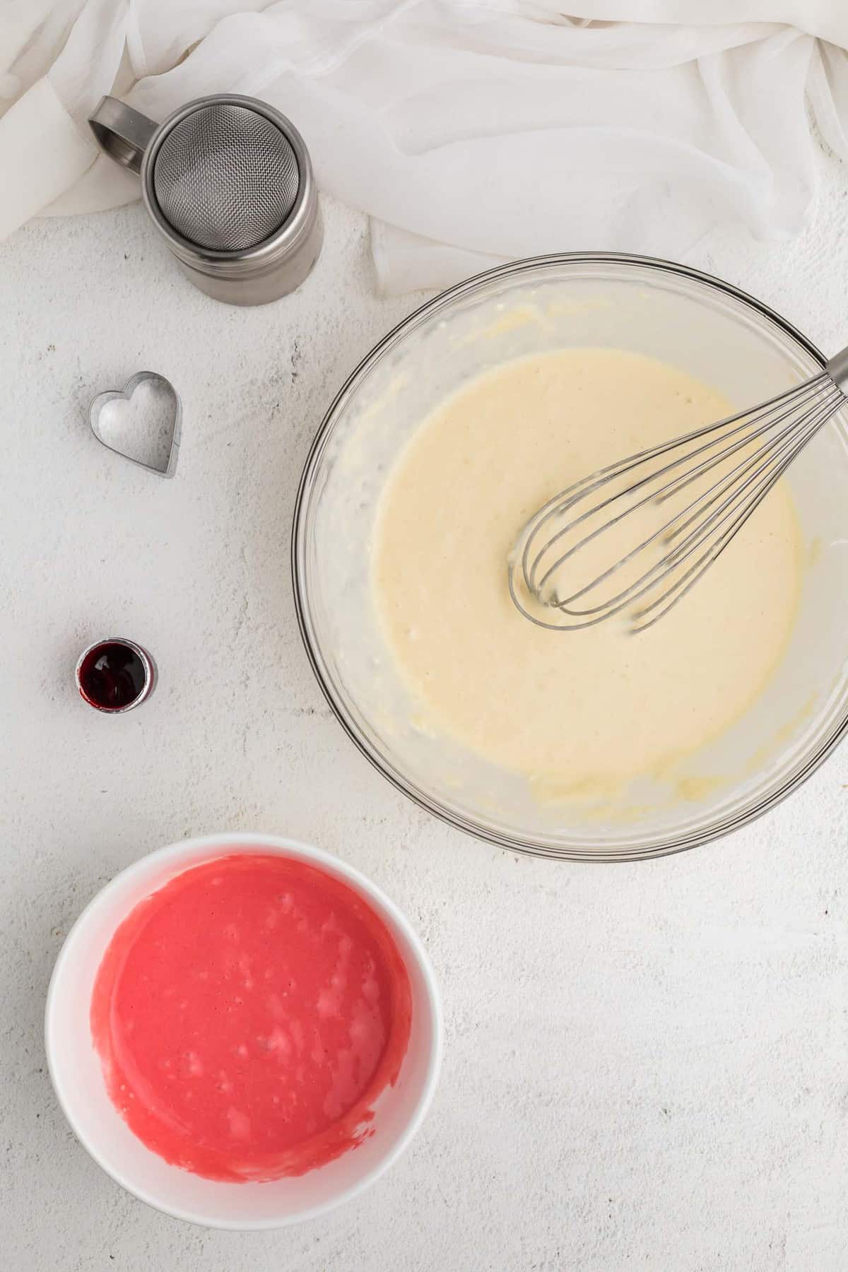Deux bols de pâte, un blanc et un rose.