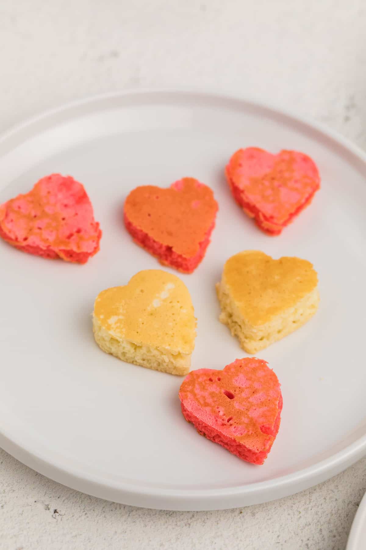 Petits pancakes en forme de cœur sur une assiette.