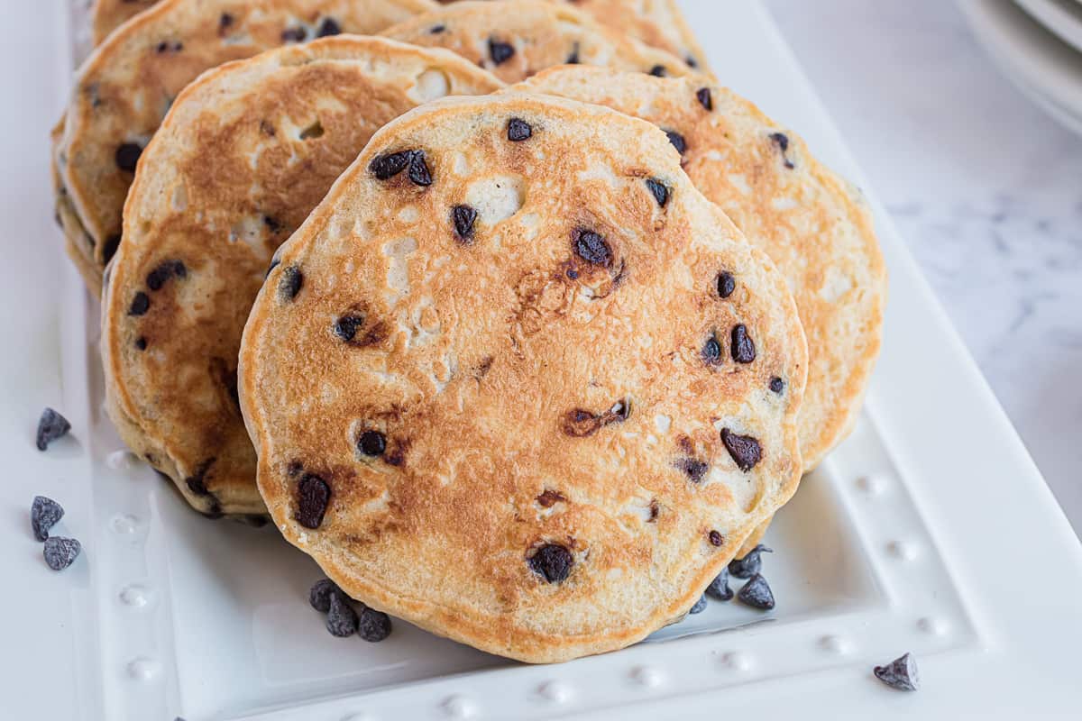 Pancakes au beurre de cacahuète avec pépites de chocolat, sur un plateau blanc.