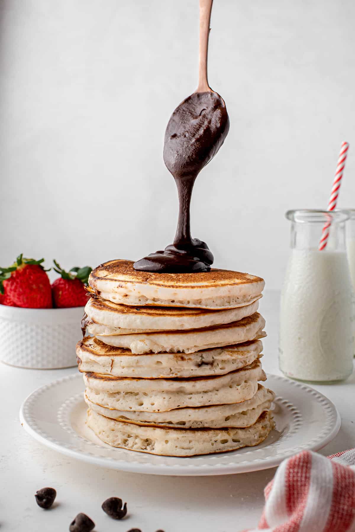 Nutella versé sur une haute pile de pancakes.