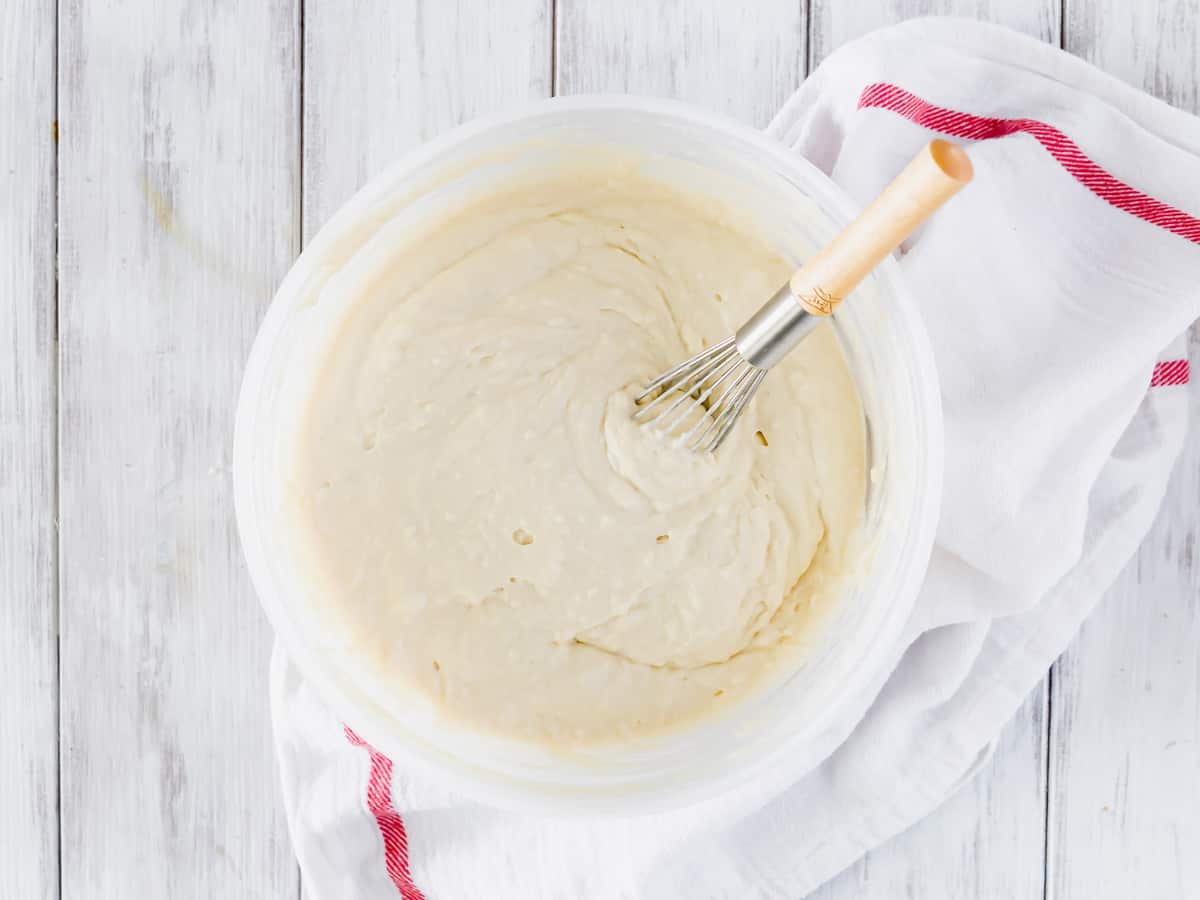 Pâte à pancakes dans un bol avec un fouet.