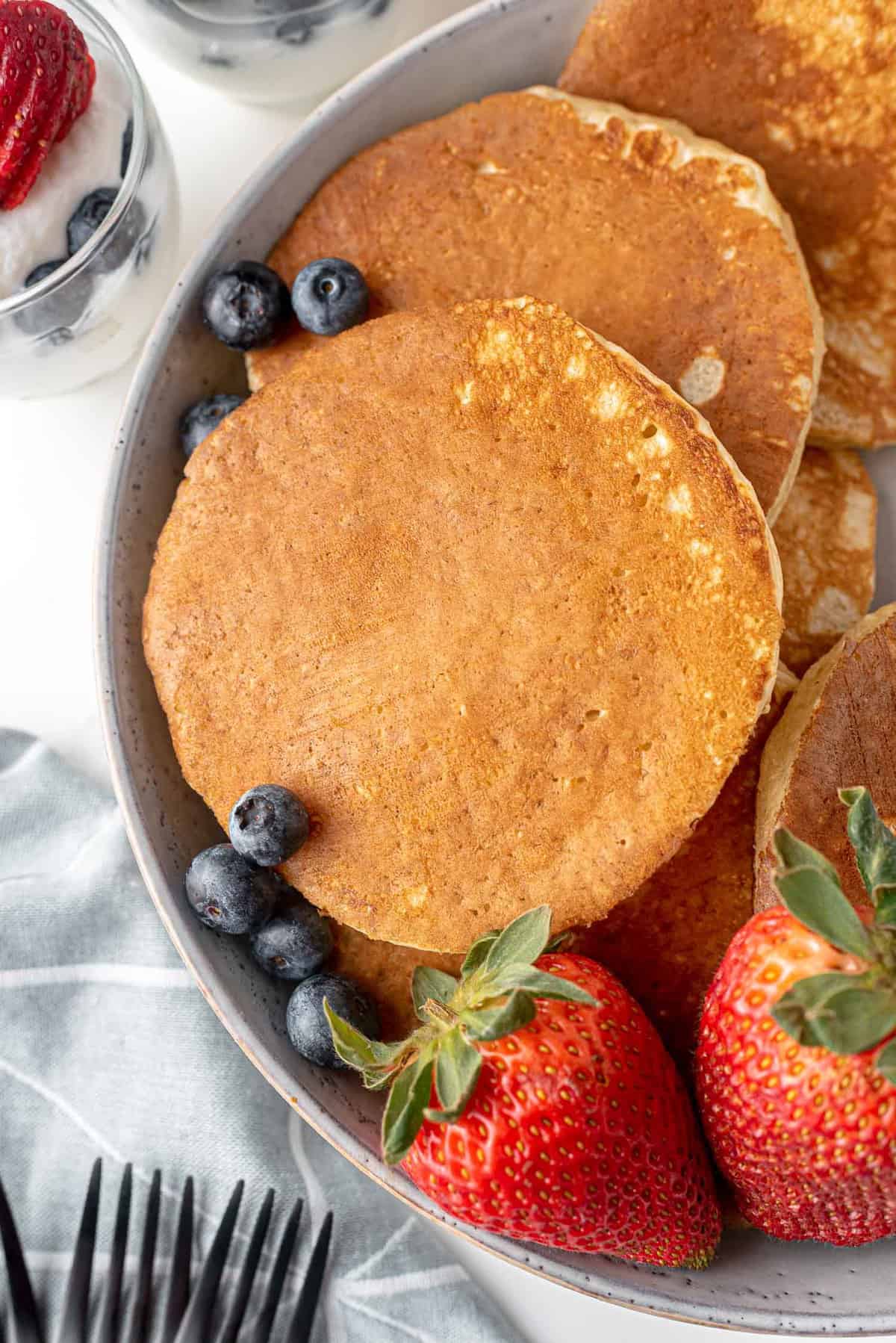 Vue d'en haut de pancakes sur un plat avec des fruits frais.