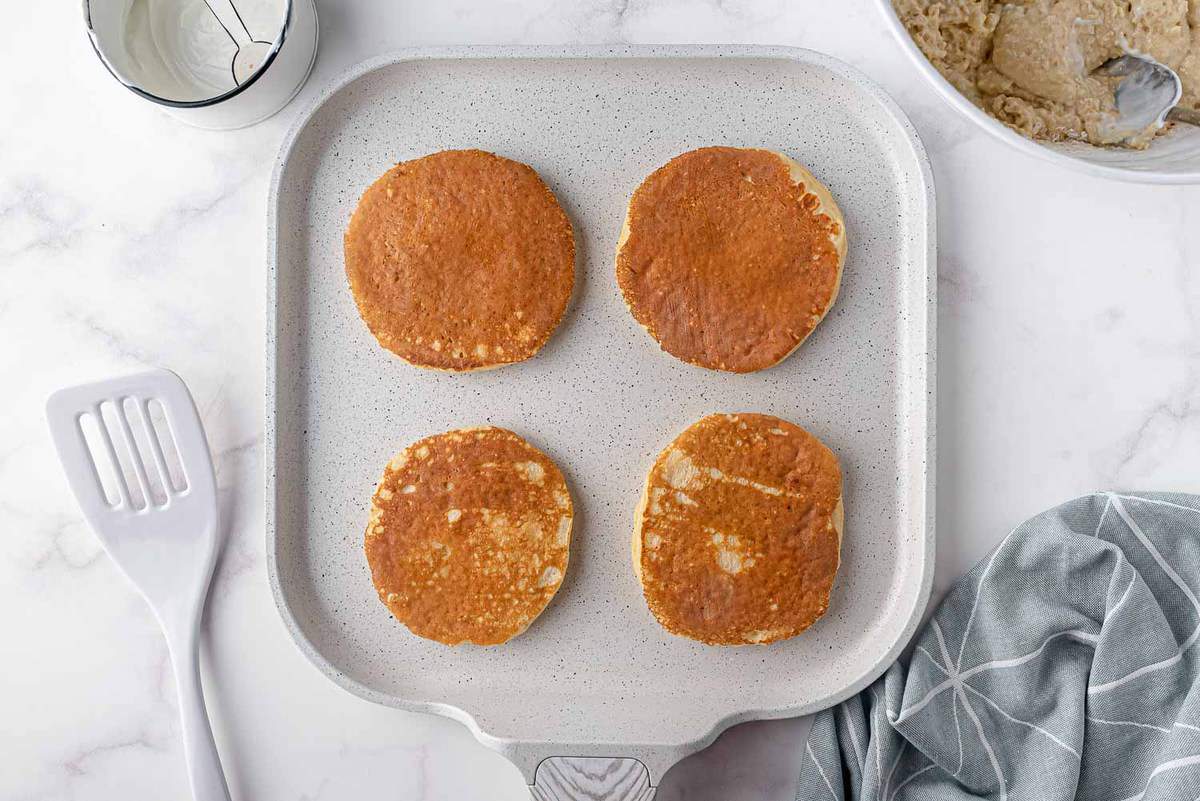 Pancakes cuits sur une plaque blanche.