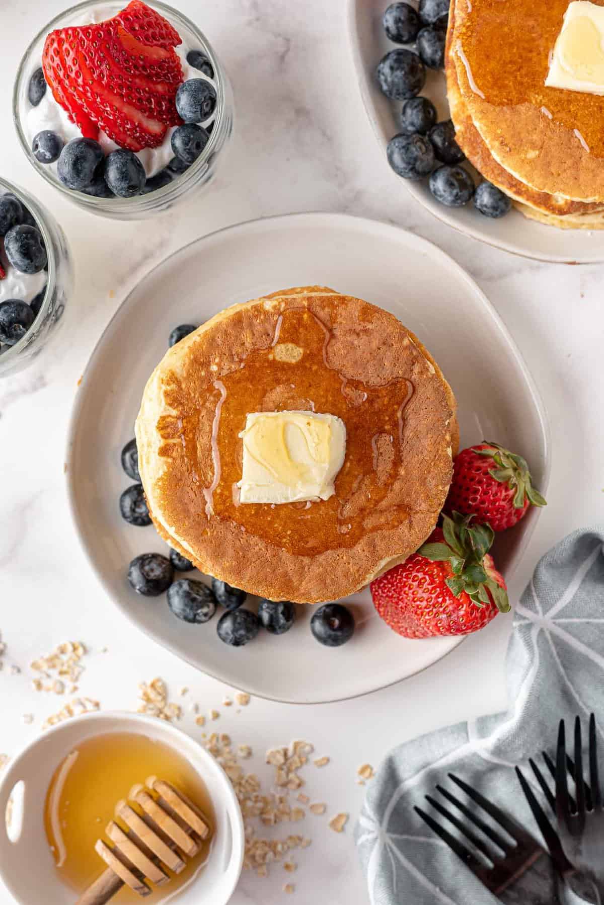 Vue d'en haut de pancakes garnis de beurre et de sirop.