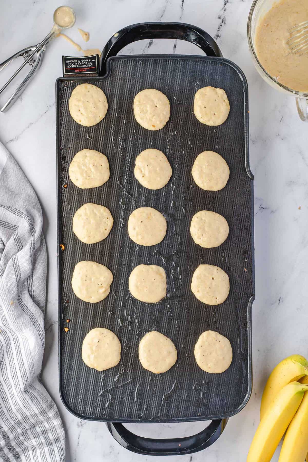 Pancakes non cuits sur une grande crêpière.