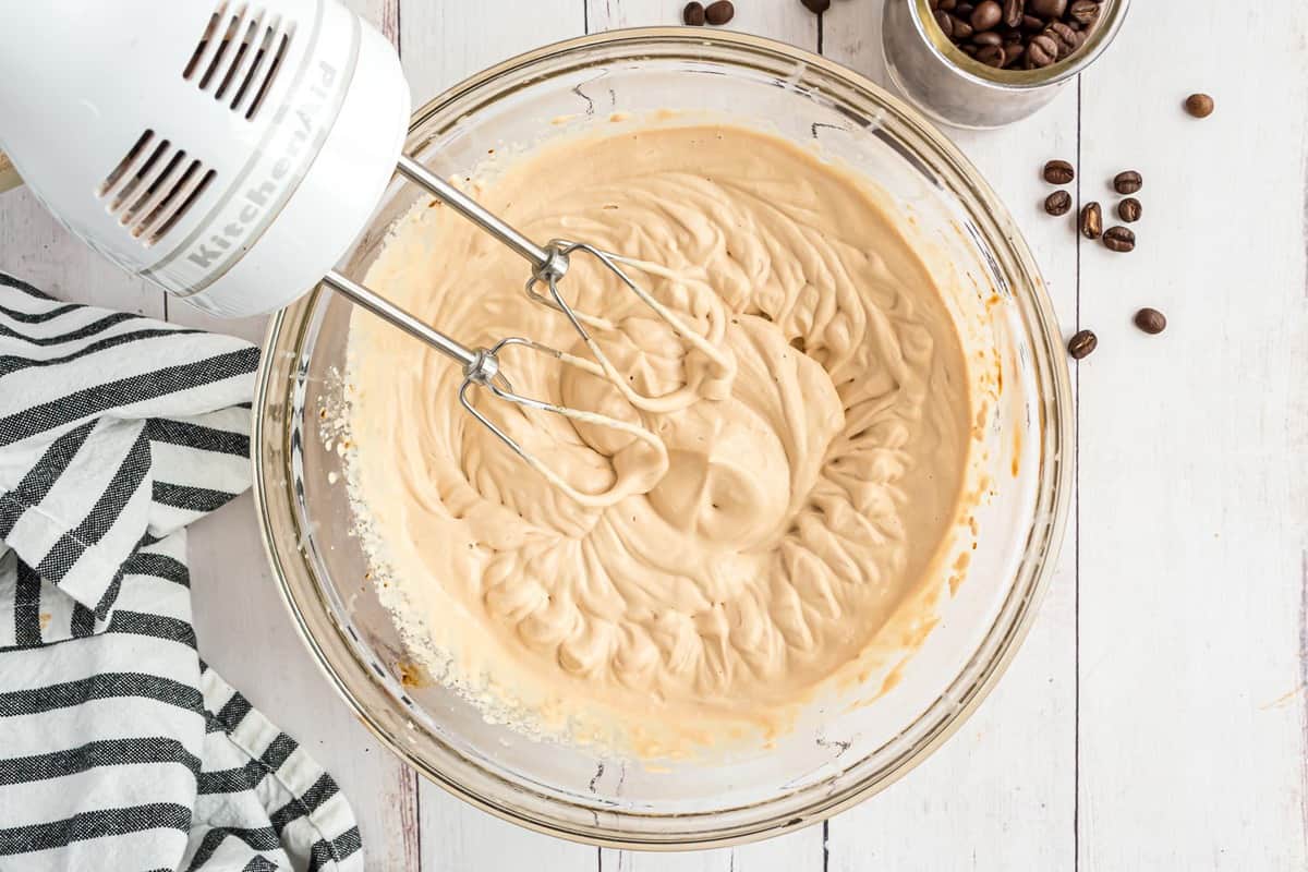 Crème battue dans un bol de mélange en verre.
