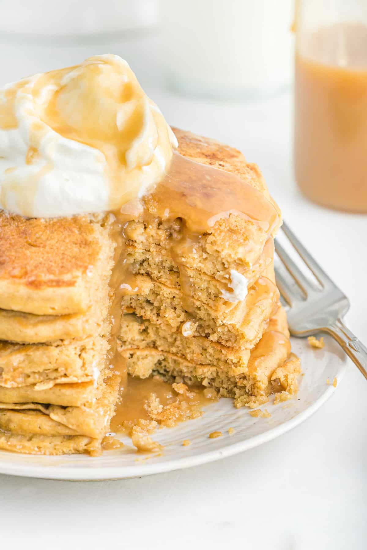 De la sauce caramel dégoulinant sur une pile de pancakes.