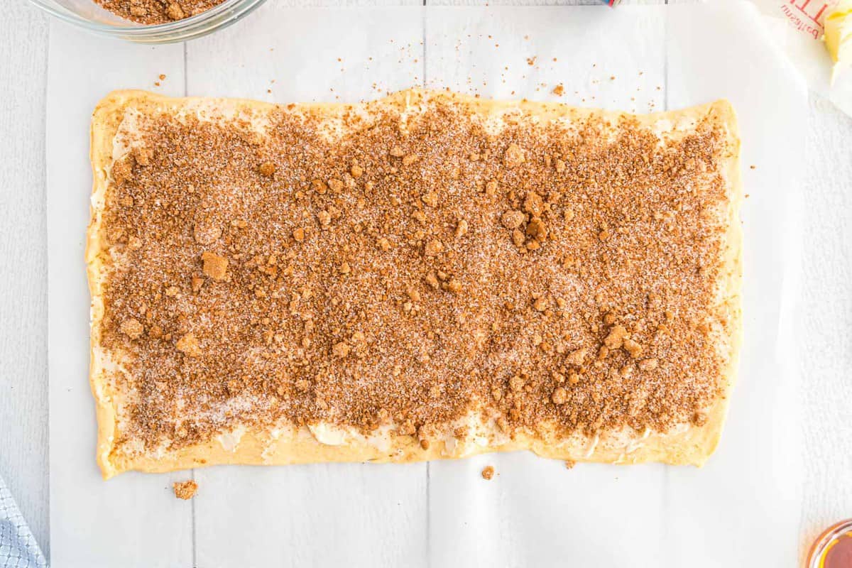 Rouleaux de pâte feuilletée saupoudrés du mélange de sucre et de cannelle.