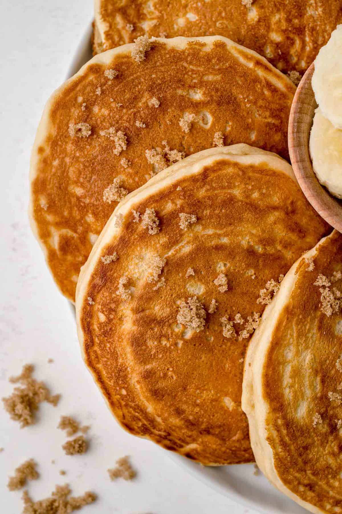 Gros plan de pancakes saupoudrés de sucre brun.