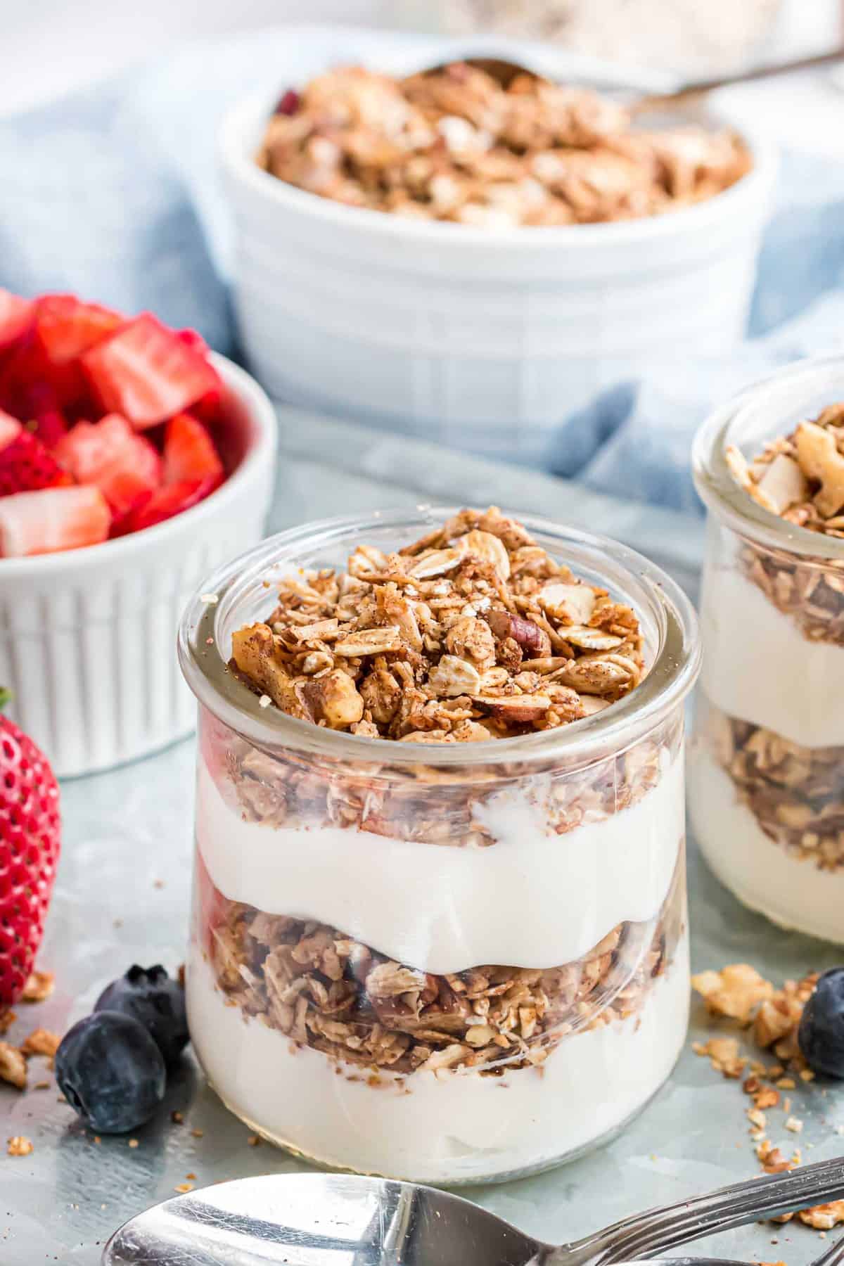 Parfait de granola dans un petit bocal en verre, superposé de yaourt.