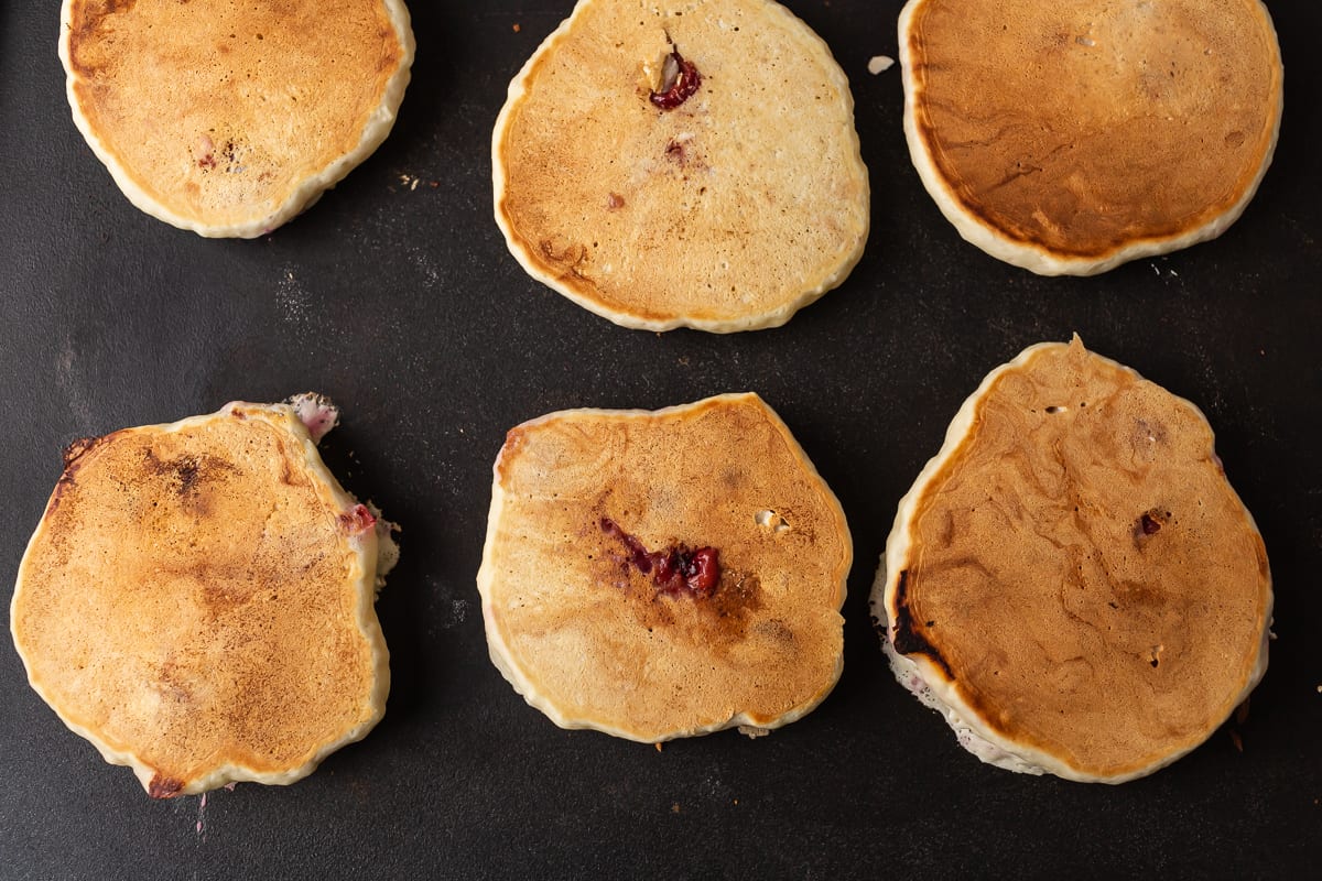Pancakes cuits sur une plaque noire.