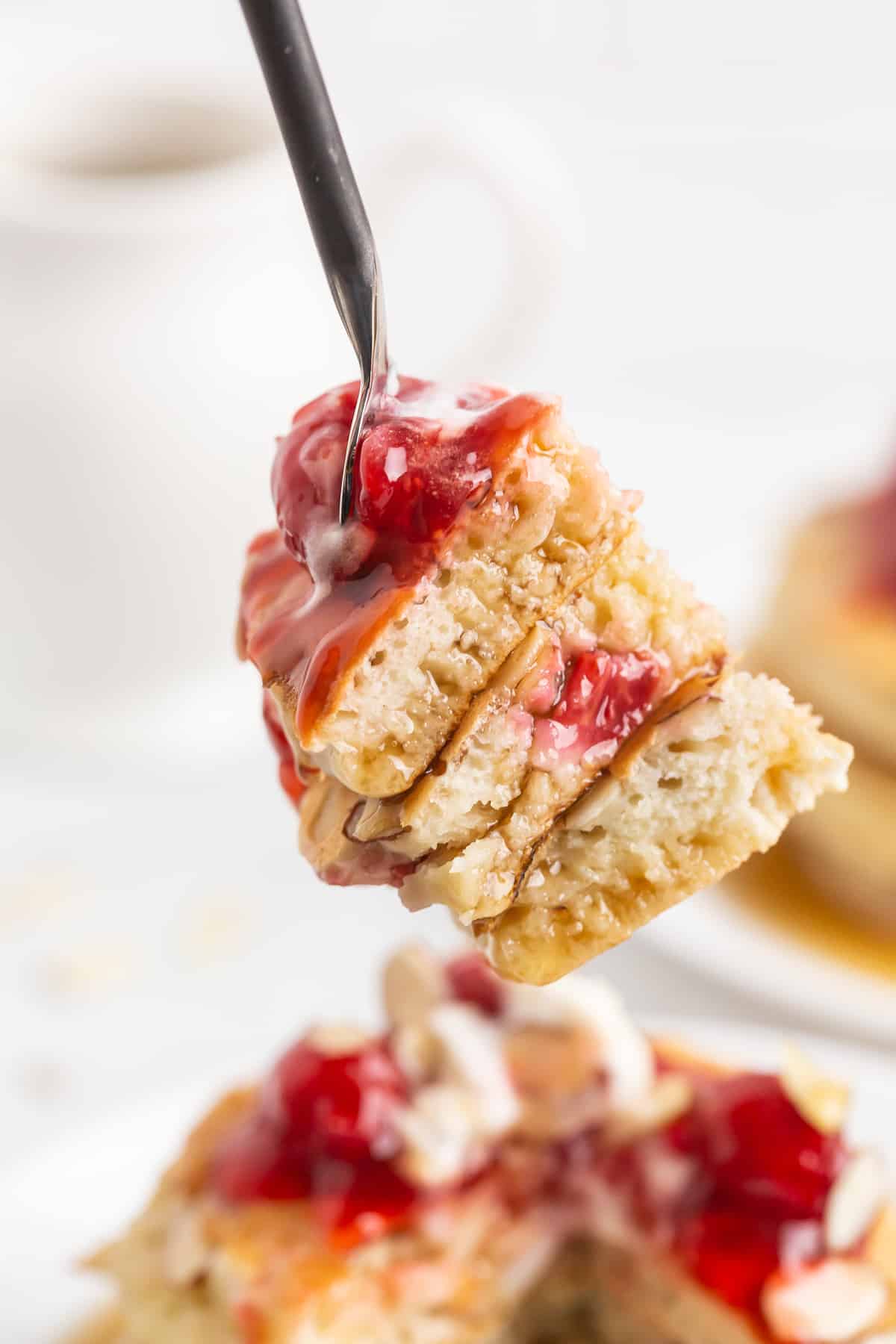 Morceaux de pancake sur une fourchette, avec des cerises.