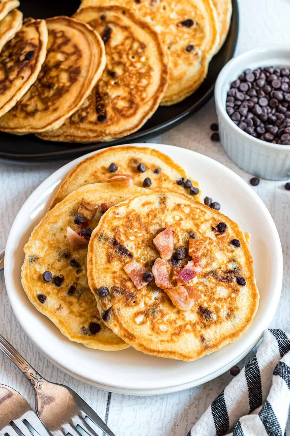 Assiette blanche avec trois pancakes au bacon et pépites de chocolat.