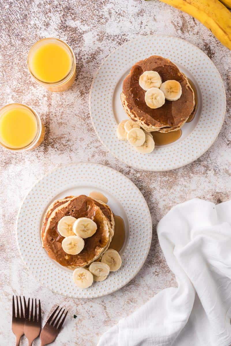Vue de dessus de piles de pancakes garnis de bananes.