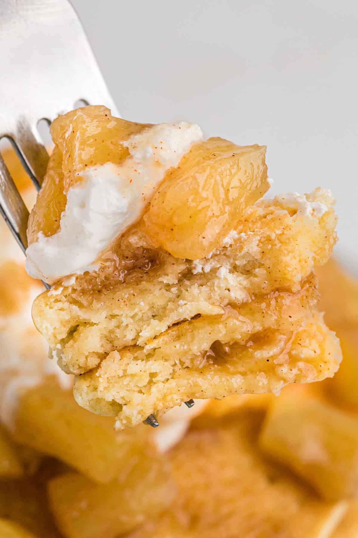 Pancakes et ananas sur une fourchette.