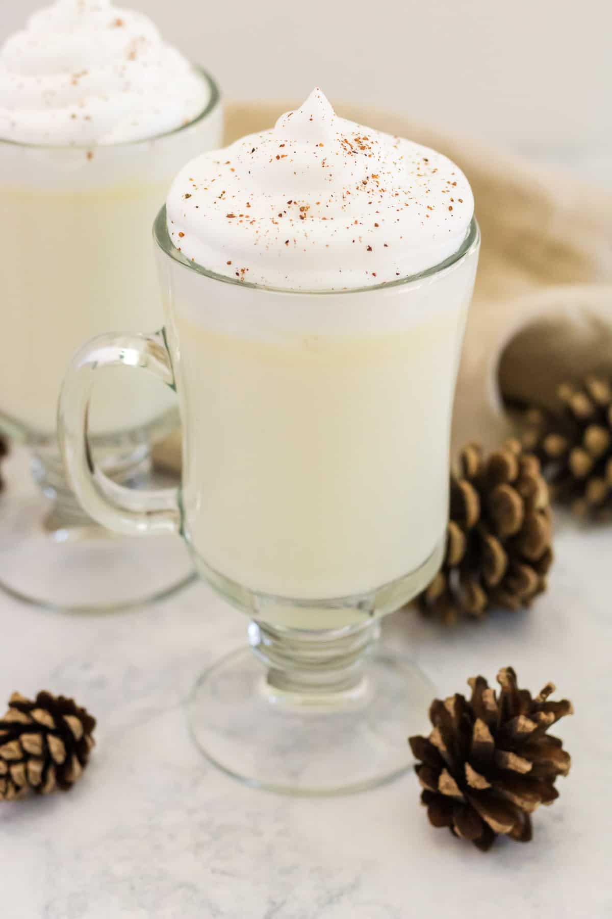 Chocolat chaud blanc décoré avec des pommes de pin.