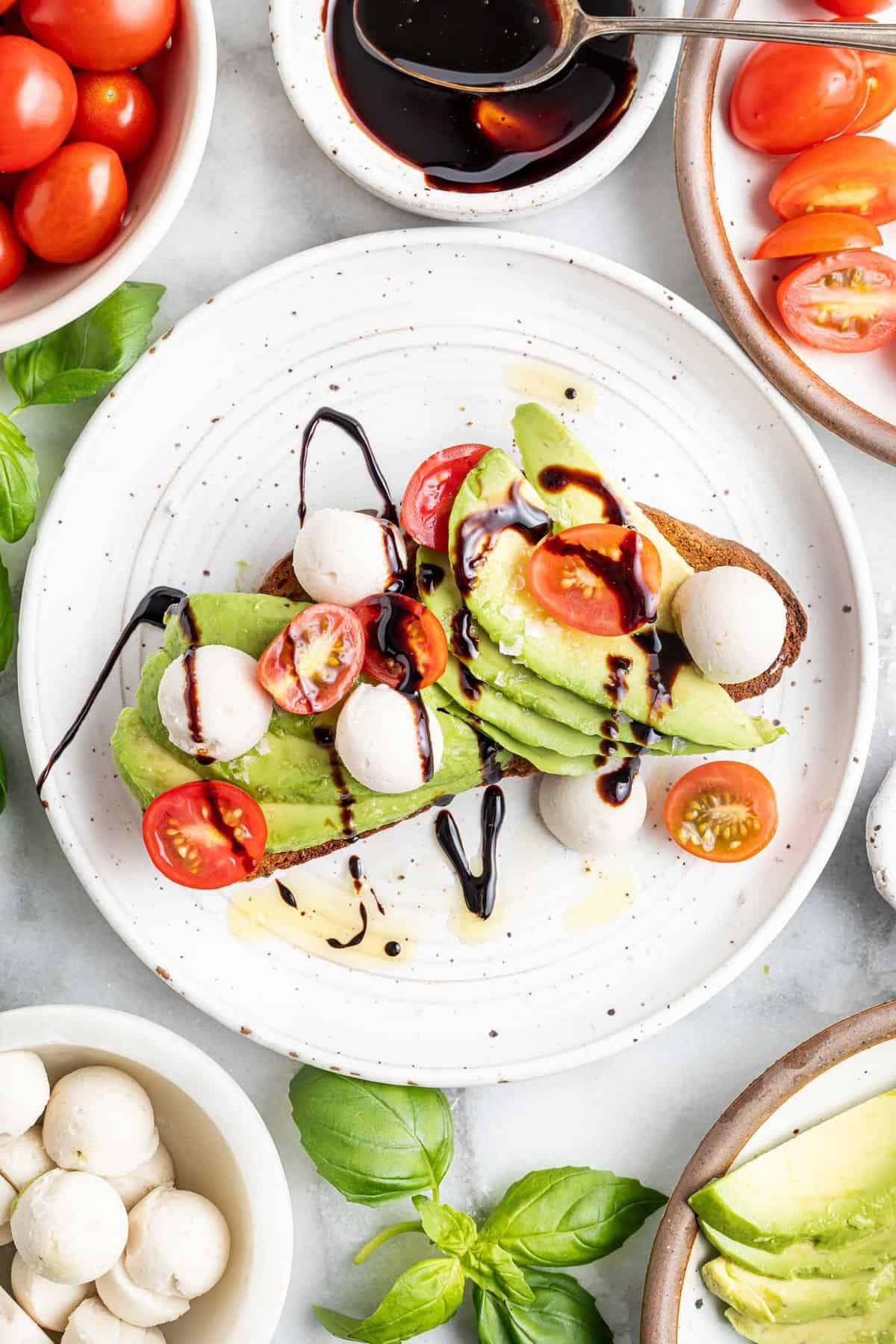 Toast à l'avocat Caprese arrosé de glaçage balsamique.
