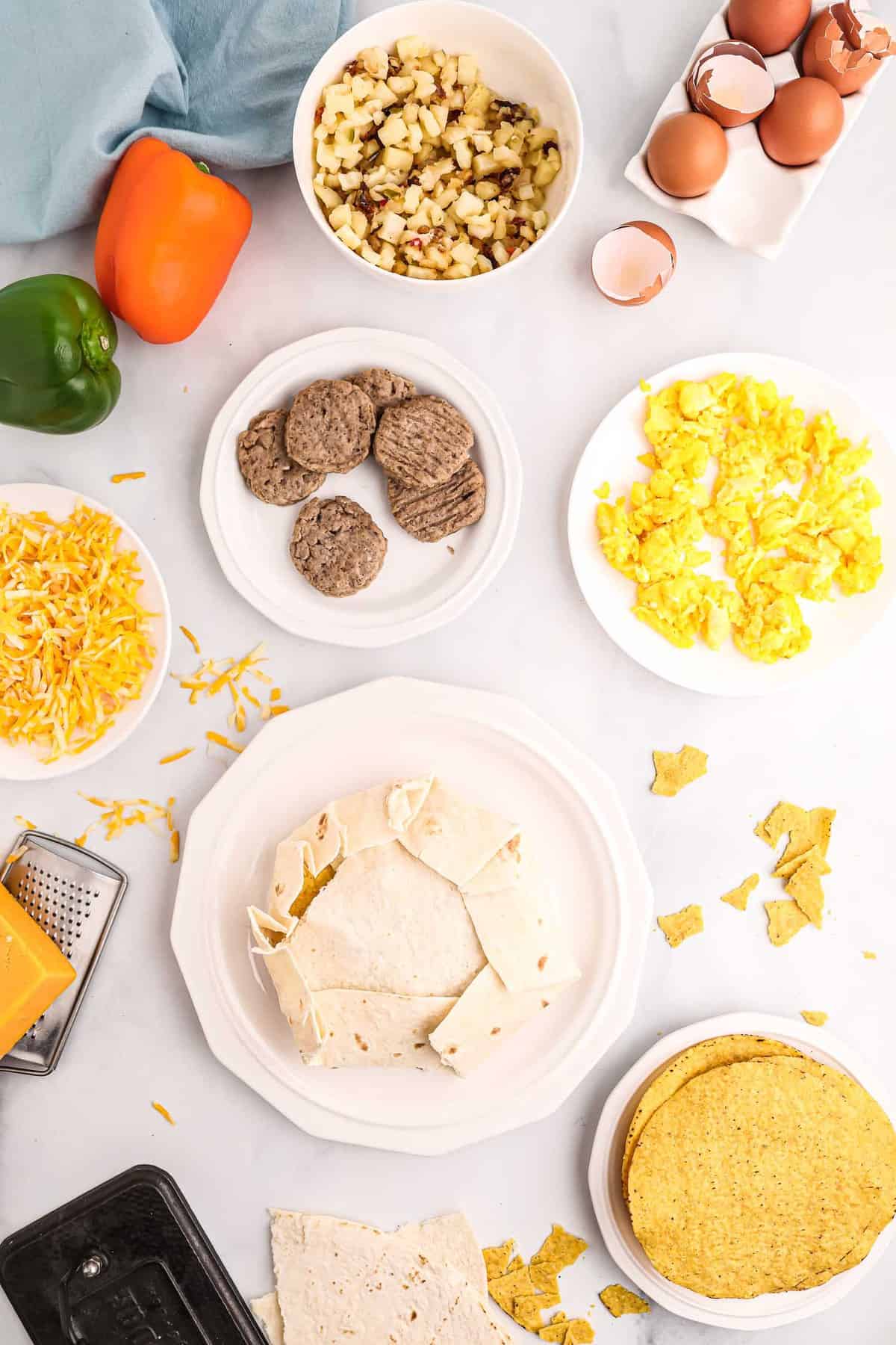 Crunchwrap non cuit, entouré d'ingrédients tels que des œufs, de la saucisse, des pommes de terre rissolées.