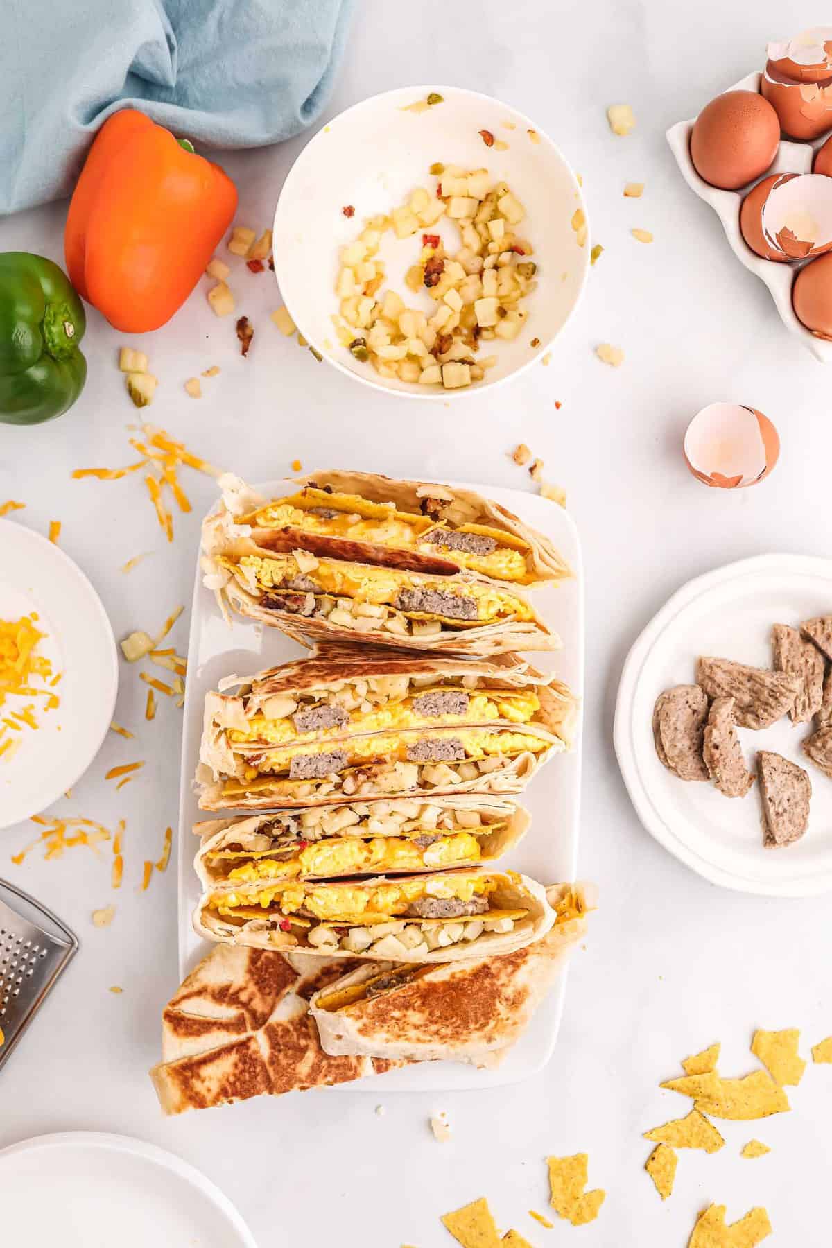 Vue aérienne de moitiés de crunchwrap alignées sur une assiette rectangulaire blanche.