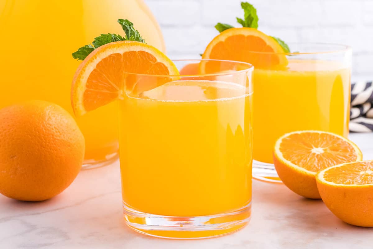 Boisson orange dans un petit verre, une autre en arrière-plan.