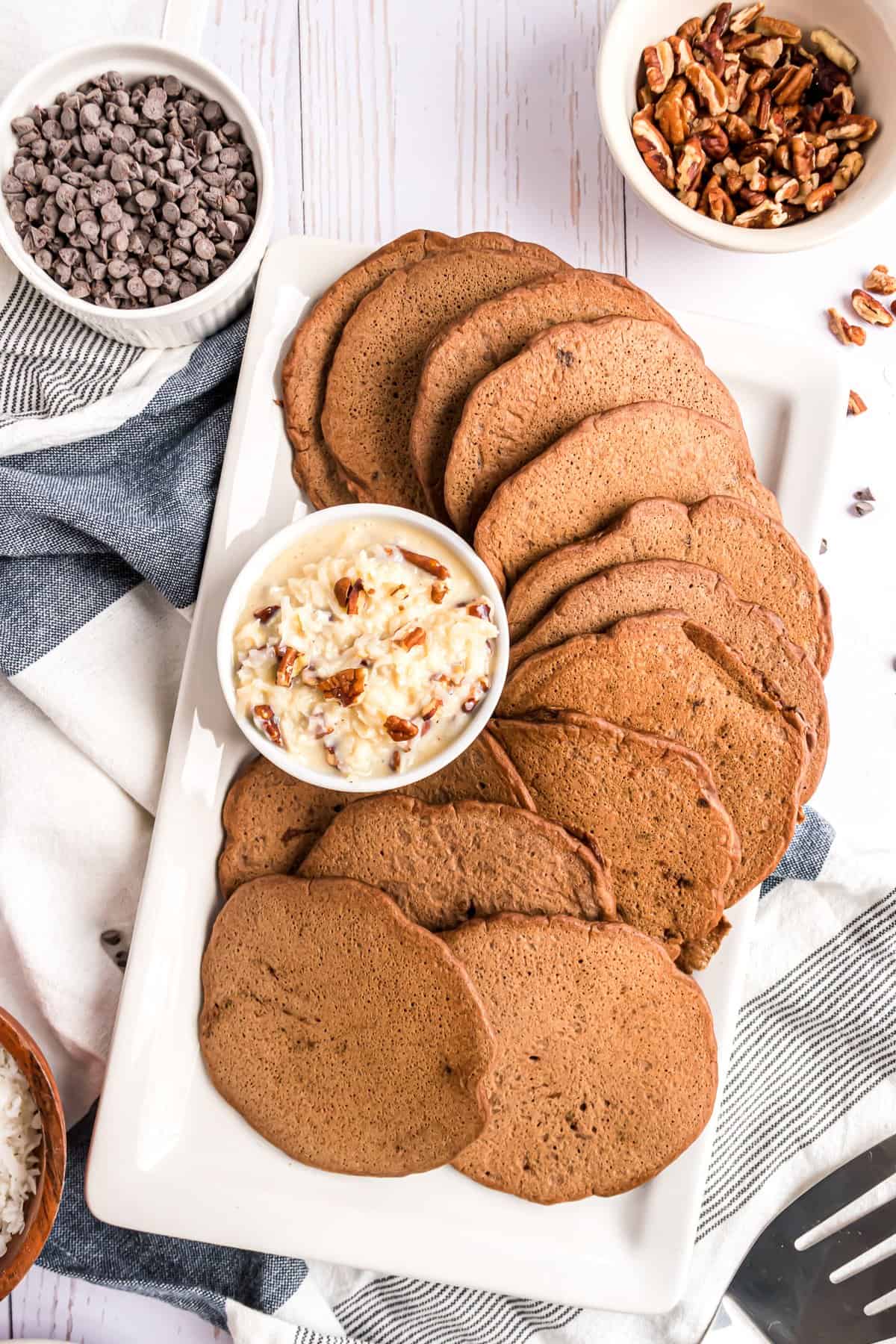 Plat de pancakes au chocolat avec une garniture de chocolat allemand dans un petit bol.