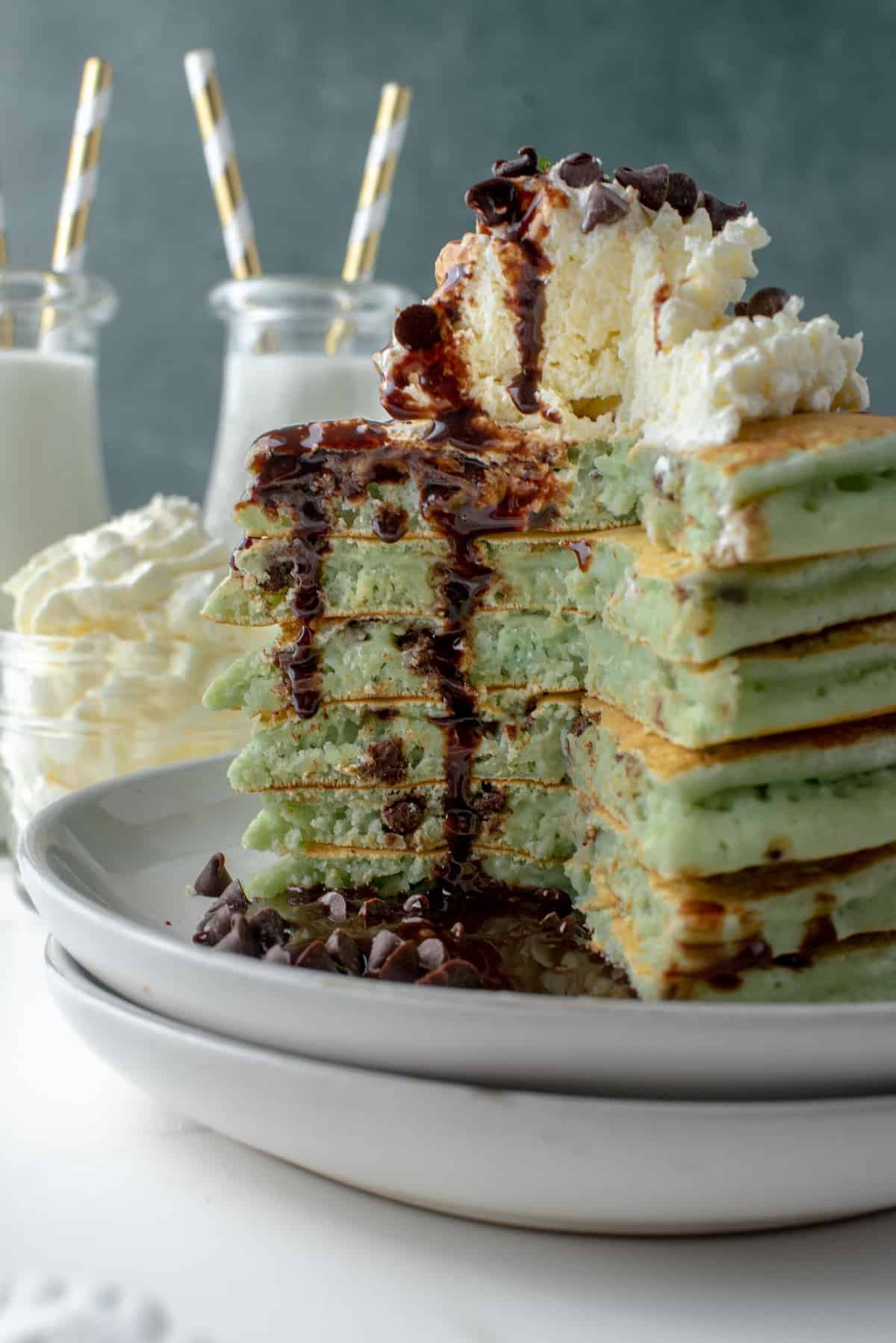 Sauce au chocolat coulant sur une pile de pancakes découpés.