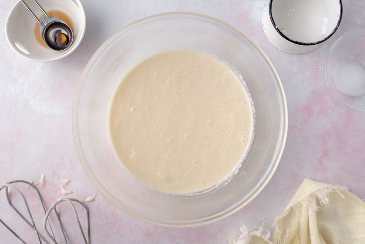Glaçage au fromage à la crème dans un bol de mélange en verre transparent.