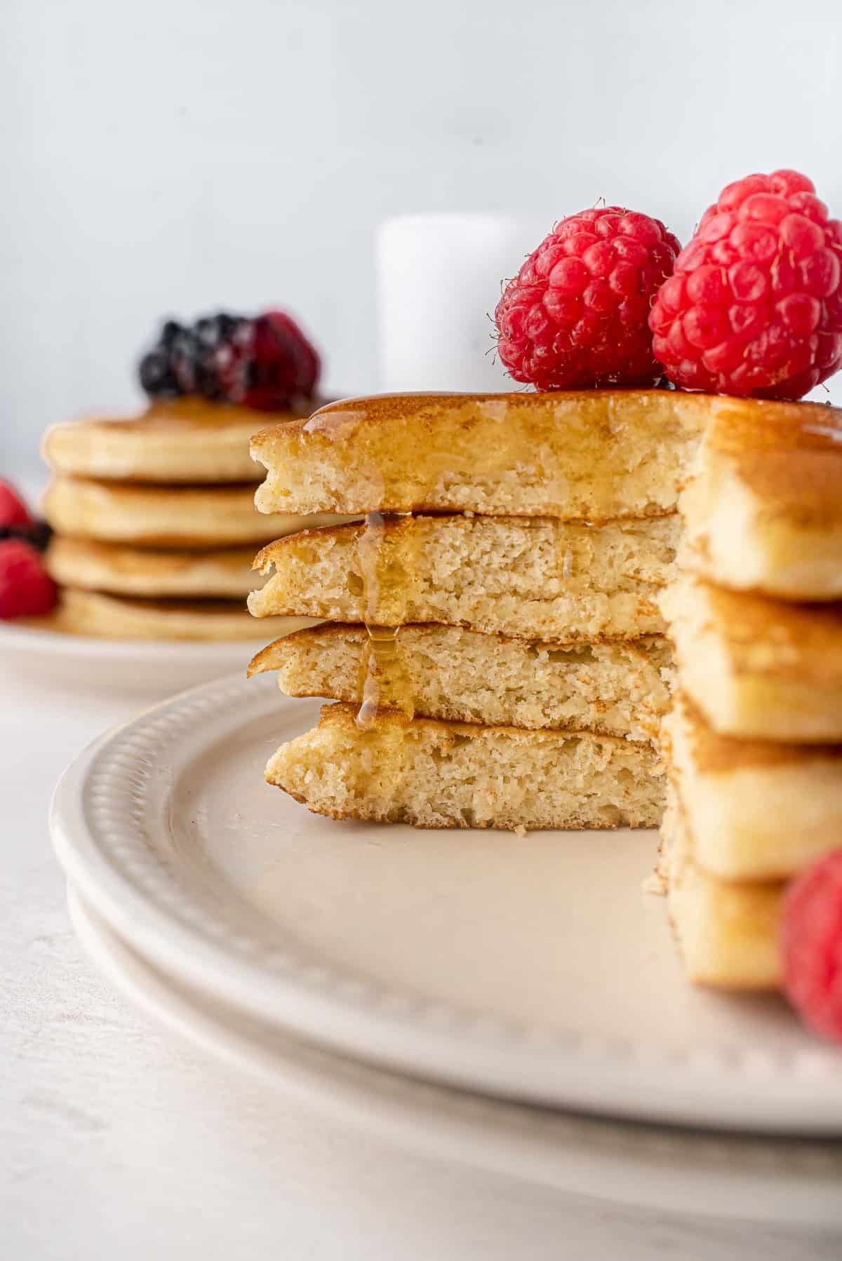 Du sirop coulant sur une pile de pancakes coupés.