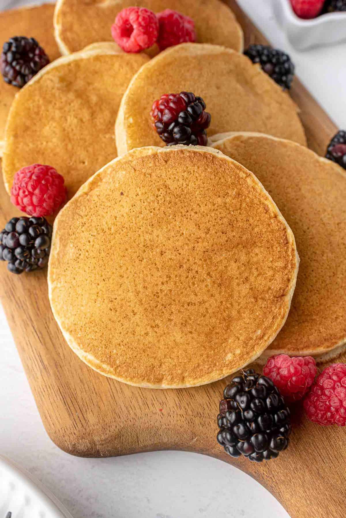 Pancakes sans produits laitiers sur un plateau en bois.