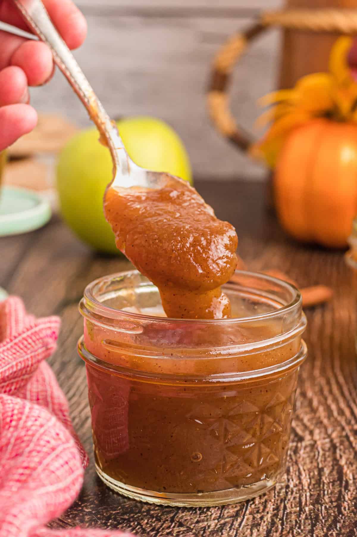 Beurre de pomme dans un petit pot avec cuillère.