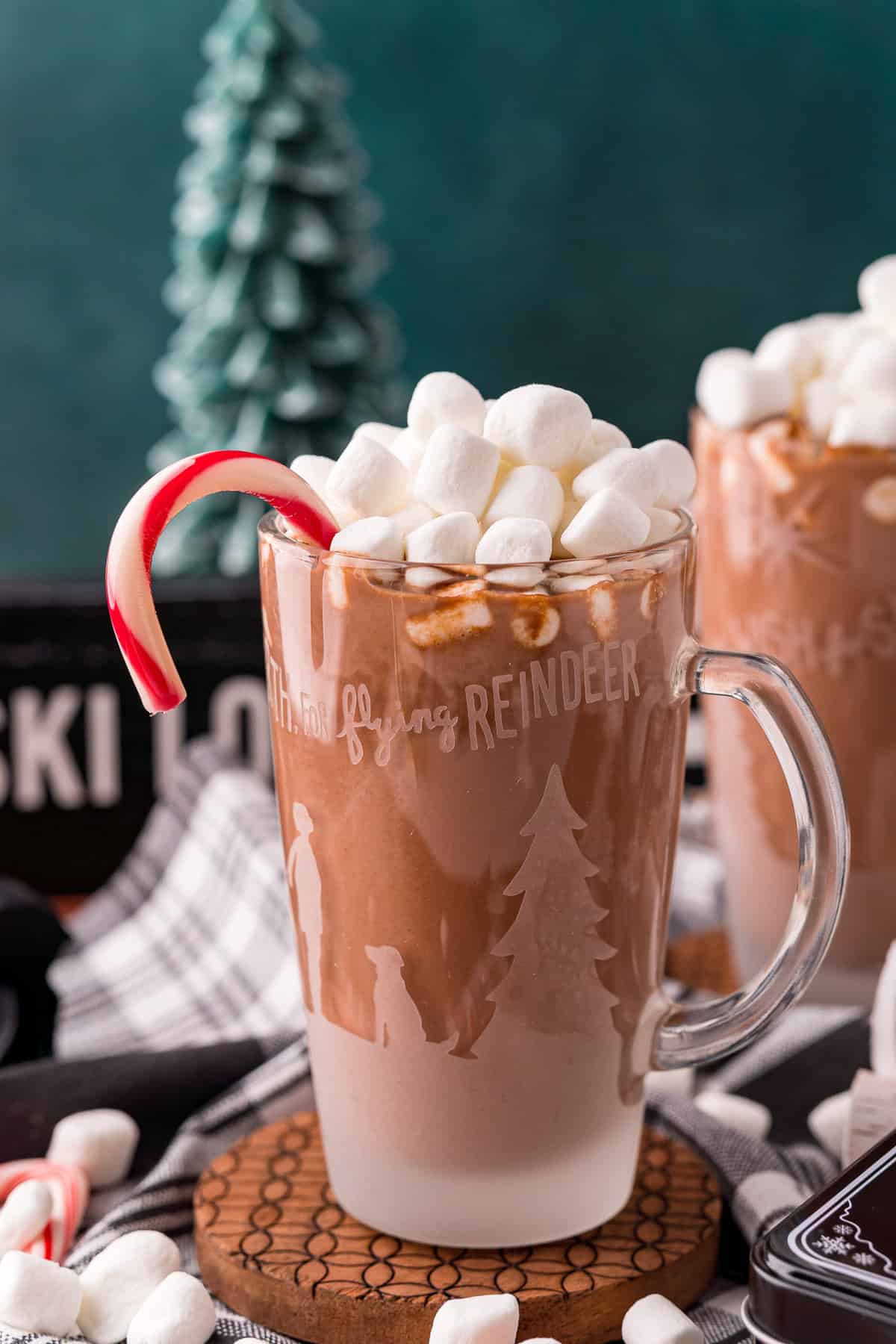 Chocolat chaud avec une canne en sucre à la menthe, des guimauves, arrière-plan vert.