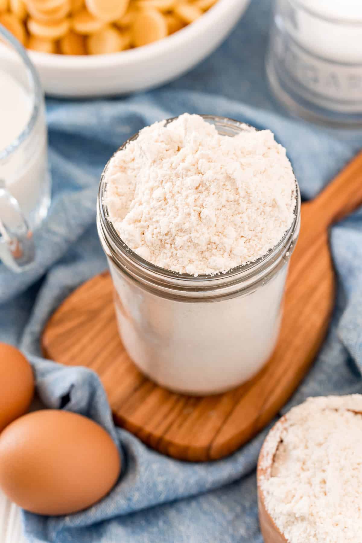Mélange Bisquick dans un pot sur un linge bleu.