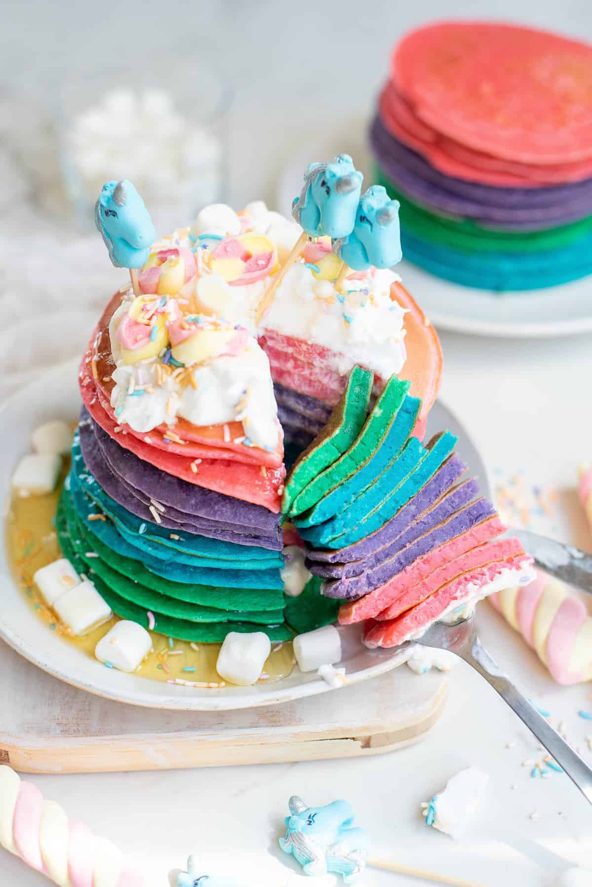 Pancakes licorne avec une part coupée pour montrer les couleurs.