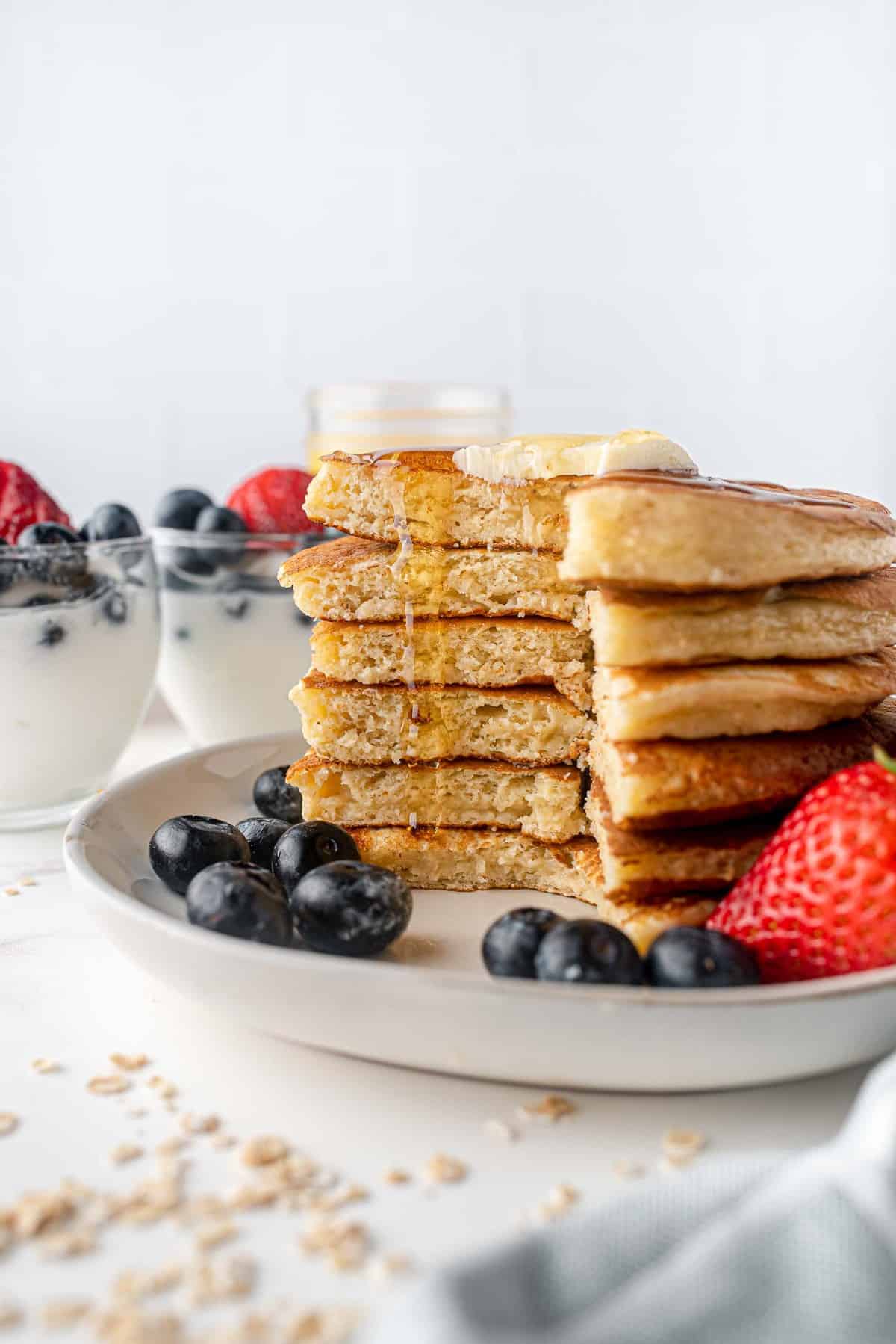Pile de pancakes avec une portion découpée, du sirop qui s'écoule.
