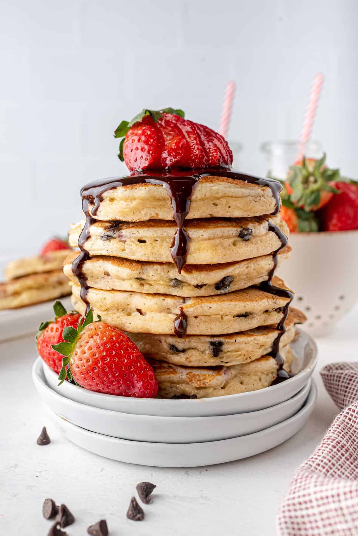 Empilement de pancakes au chocolat et aux fraises garni de sirop au chocolat.