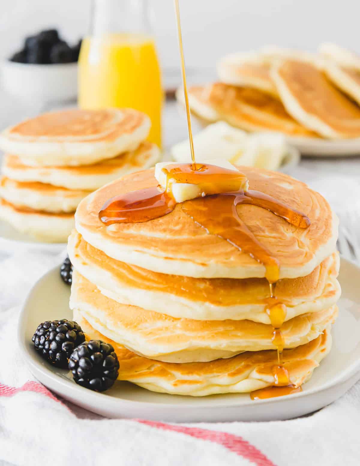 Sirop versé sur une pile de pancakes moelleux.
