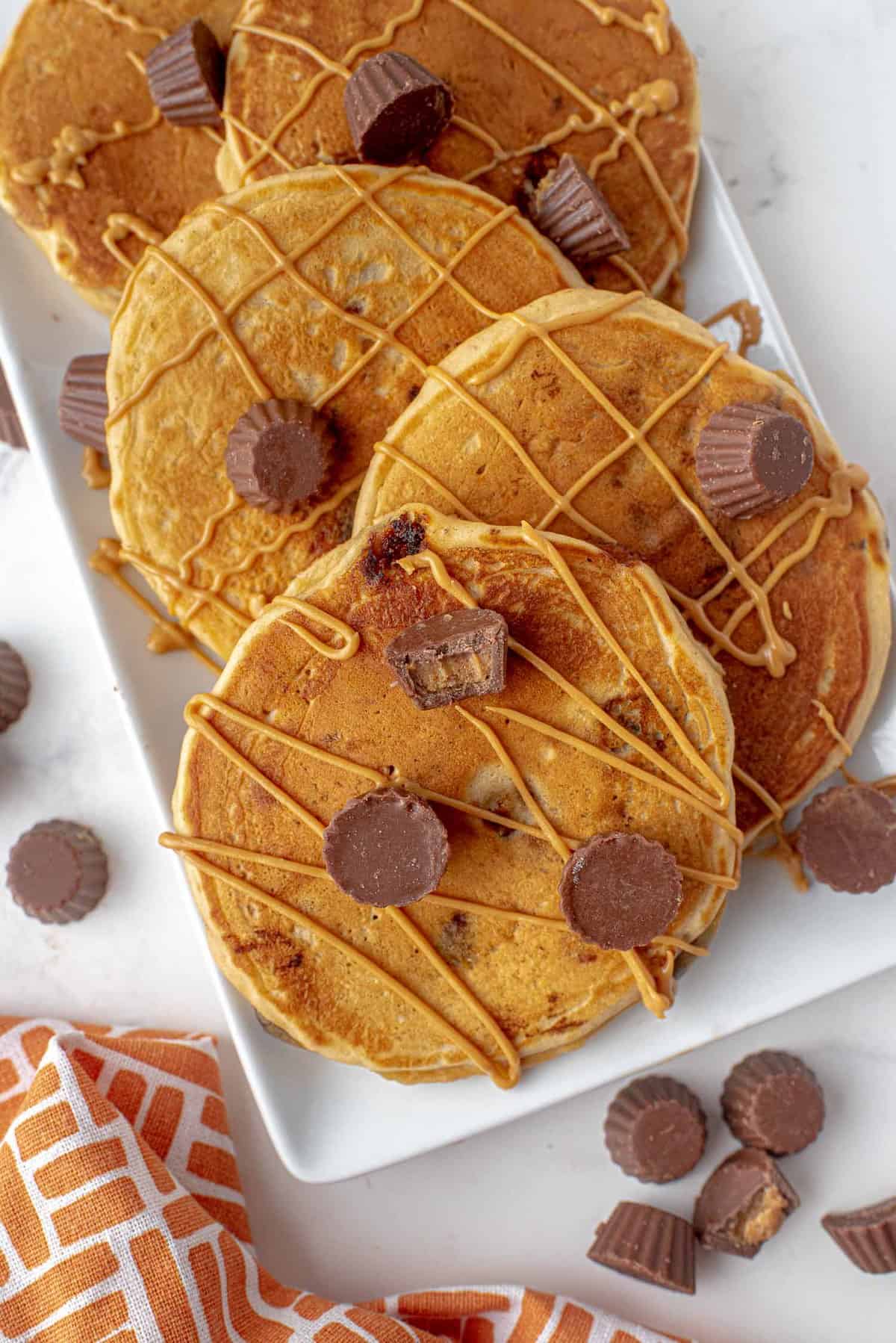 Pancakes aux cups de beurre de cacahuète Reese's arrosés de beurre de cacahuète.