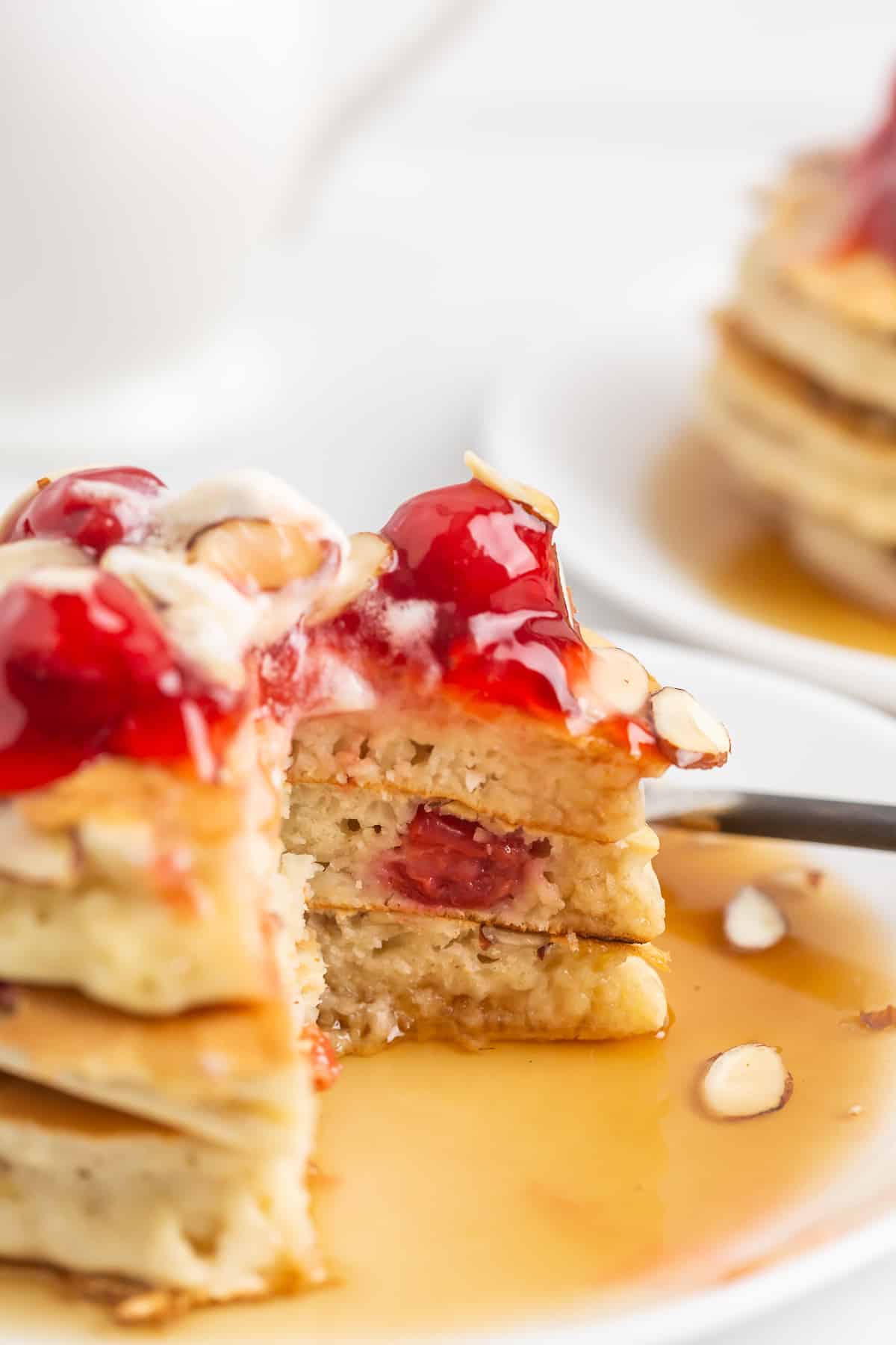 Pancakes avec des cerises et des amandes, une pile de trois.